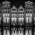 Amsterdam world famous canals at the Damrak in double mirror image