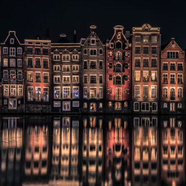 Spiegelend grachtenwater aan het Damrak in Amsterdam